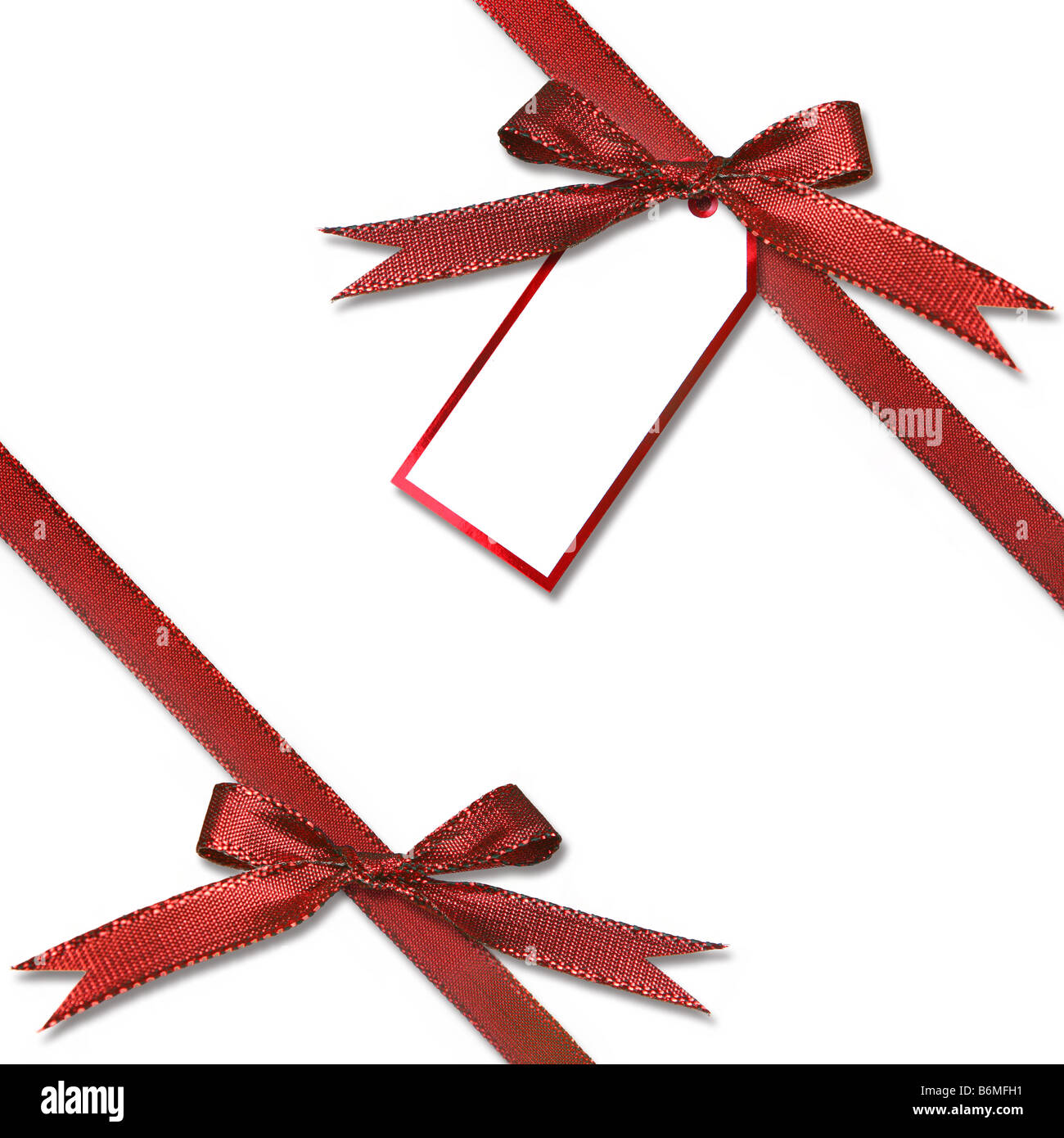 Christmas Gift Tag Hanging from a Present With Tied Red Bow Stock Photo