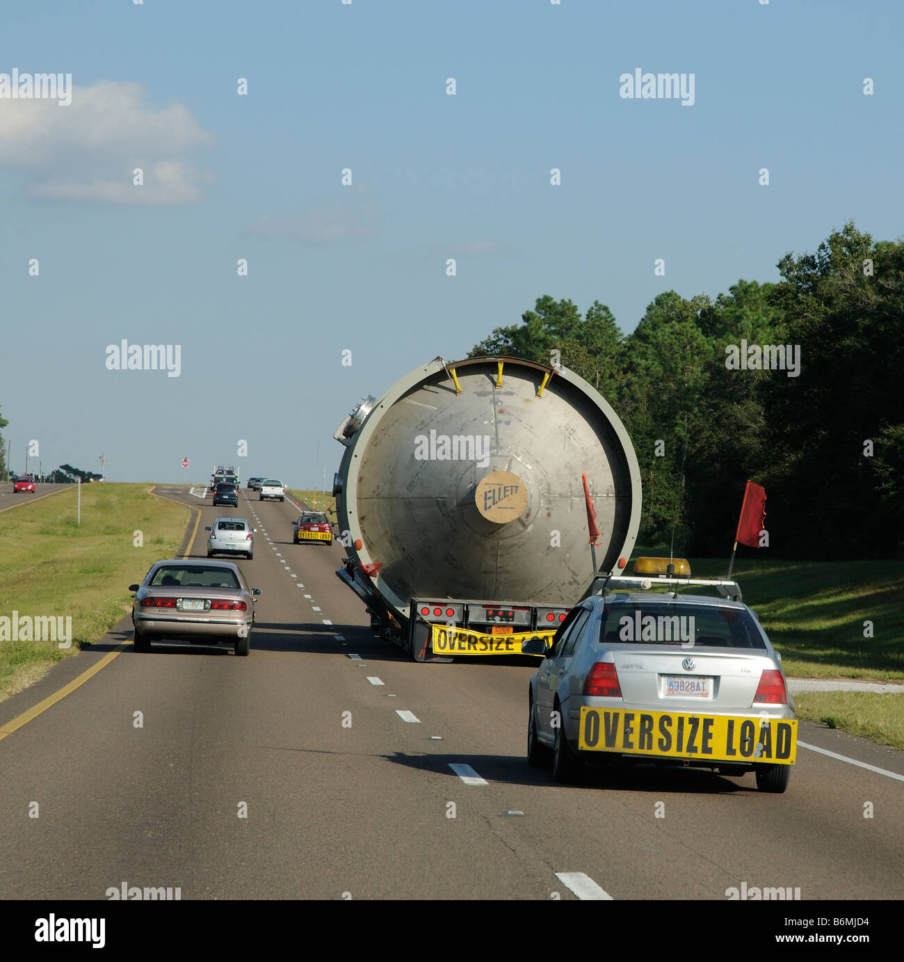 Wide and oversize load on a lowloader truck with escort vehicles