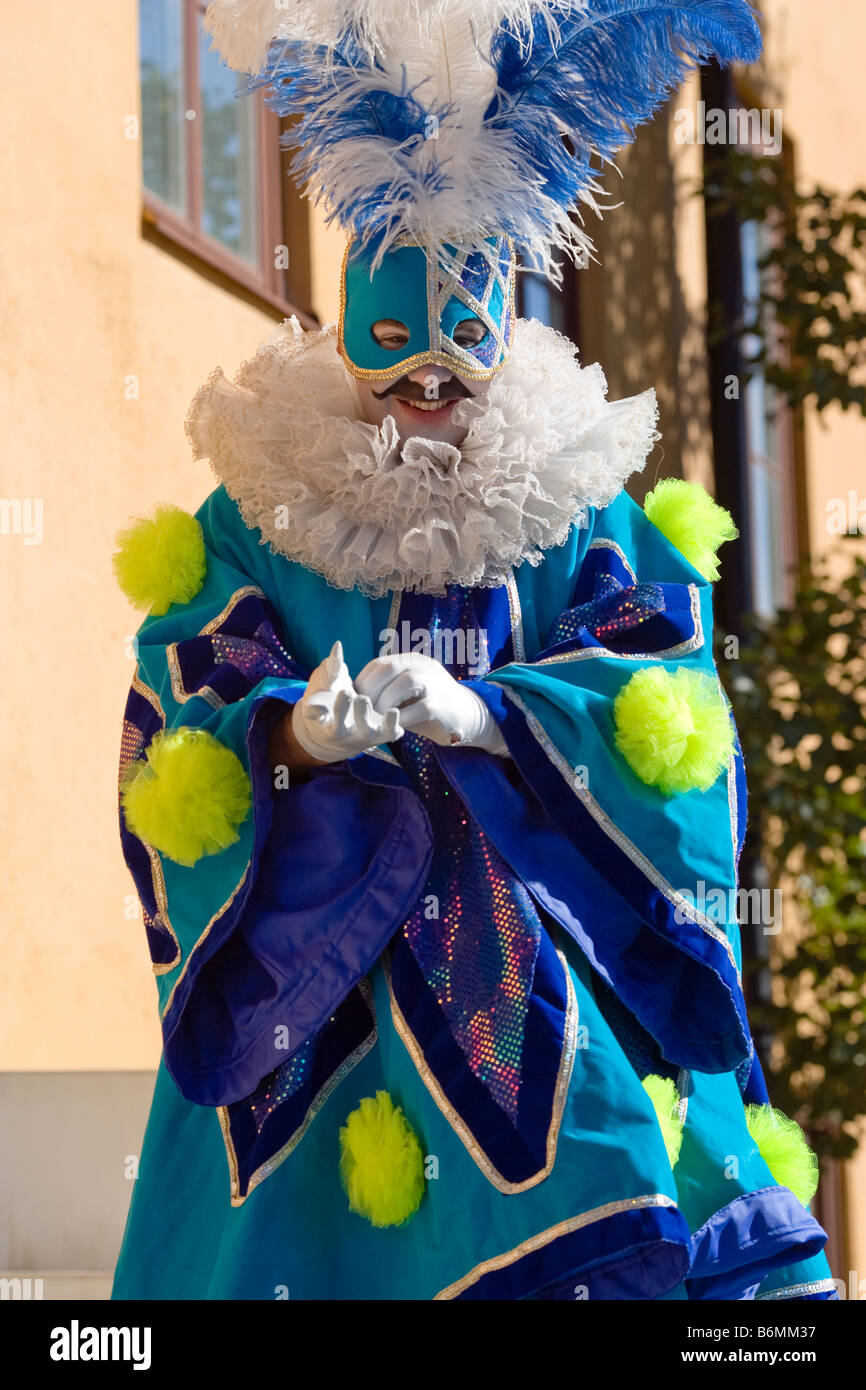 Man wearing colorful costume standing on stilts Stock Photo Alamy