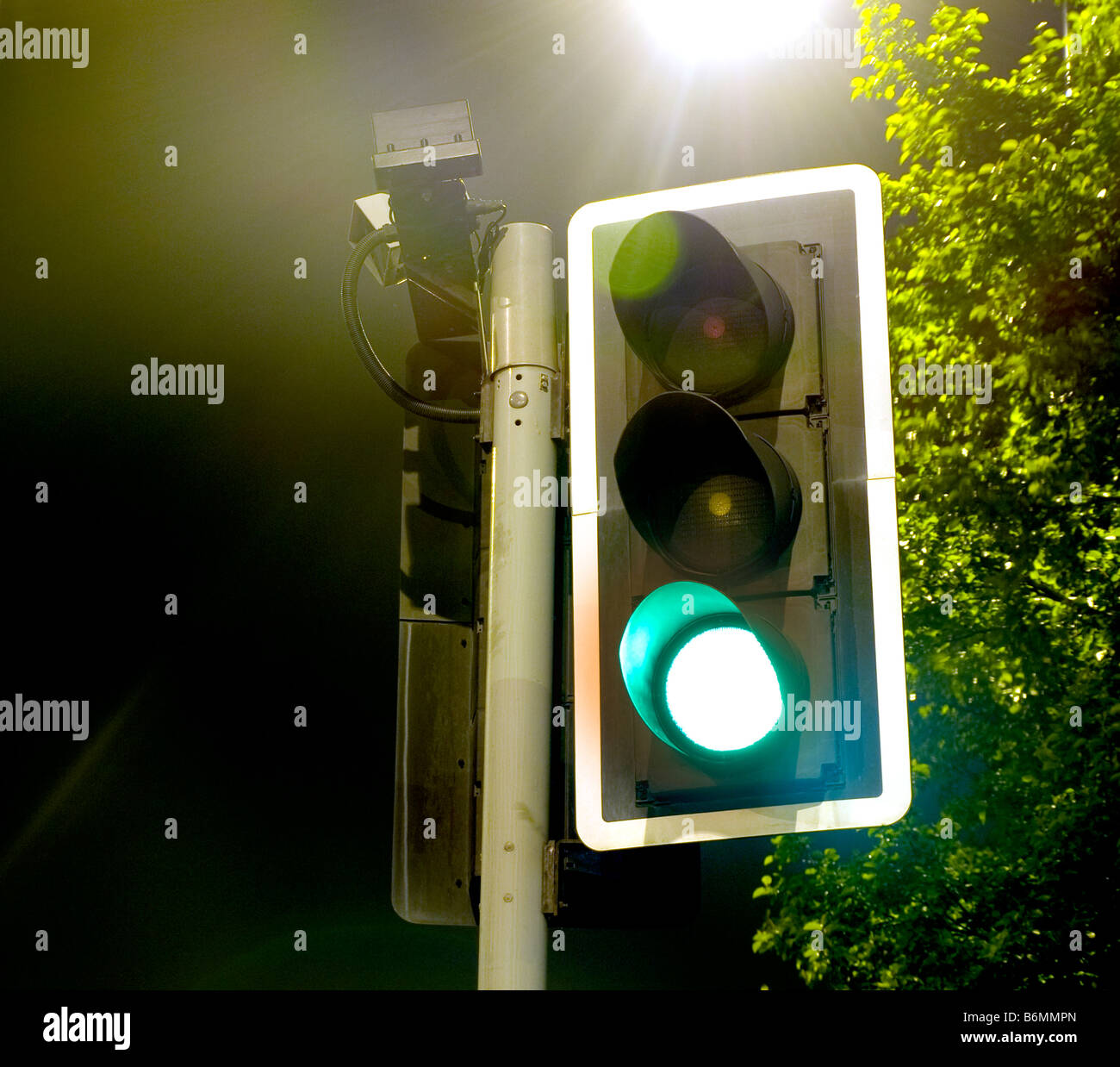 Traffic Lights near a Bright Lamp at Night Stock Photo Alamy