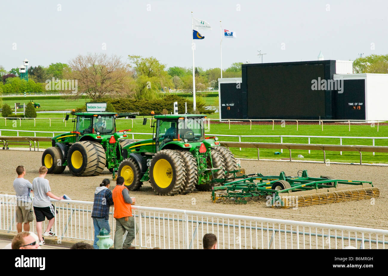Synthetic turf at horse race track being groomed by tractors Stock