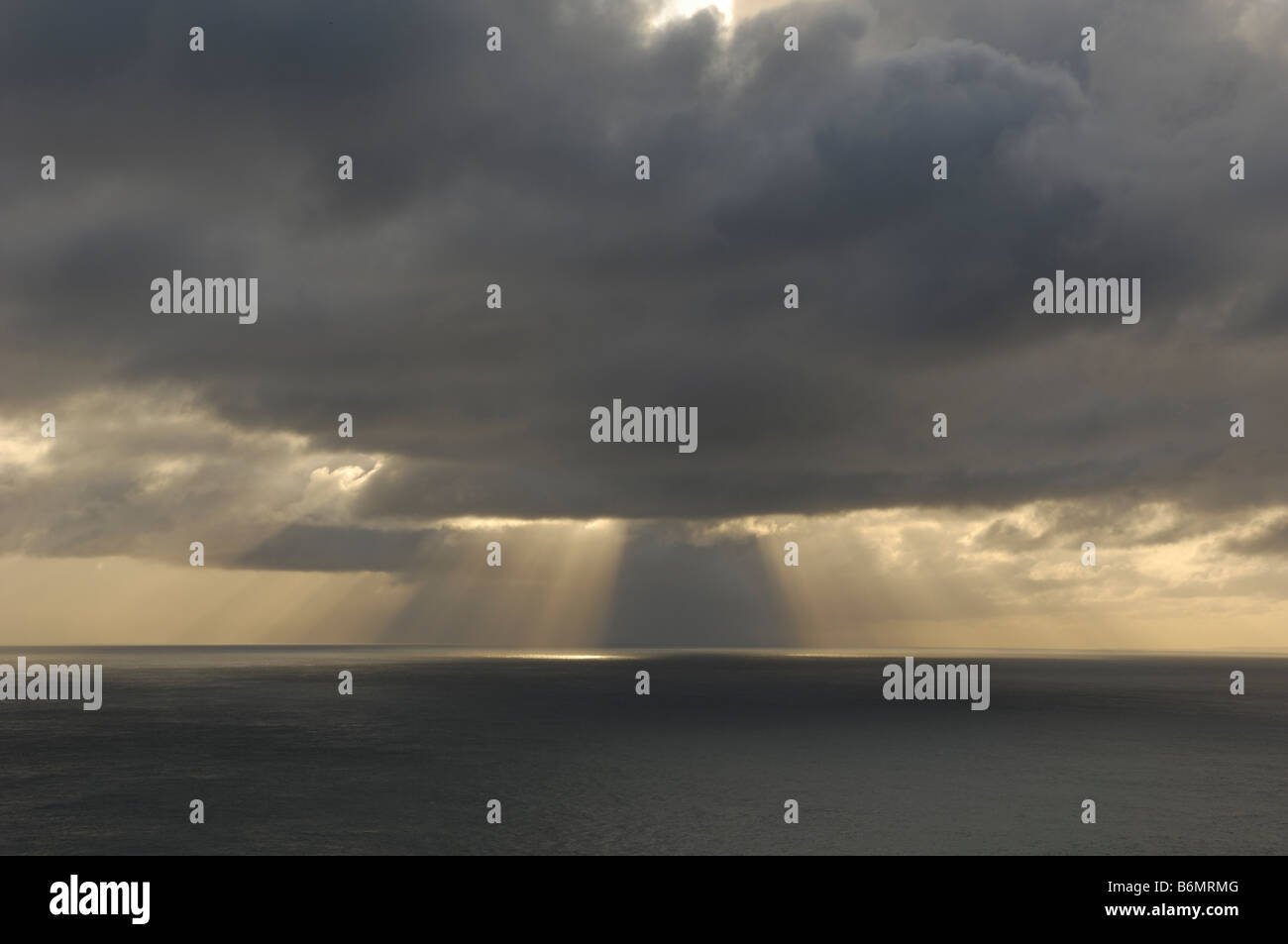 Shafts of sunlight break through the cloud over the sea Stock Photo