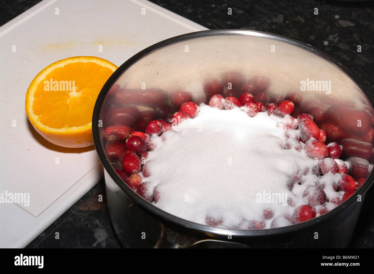 Cranberries in a Saucepan with Castor Sugar Added Stock Photo