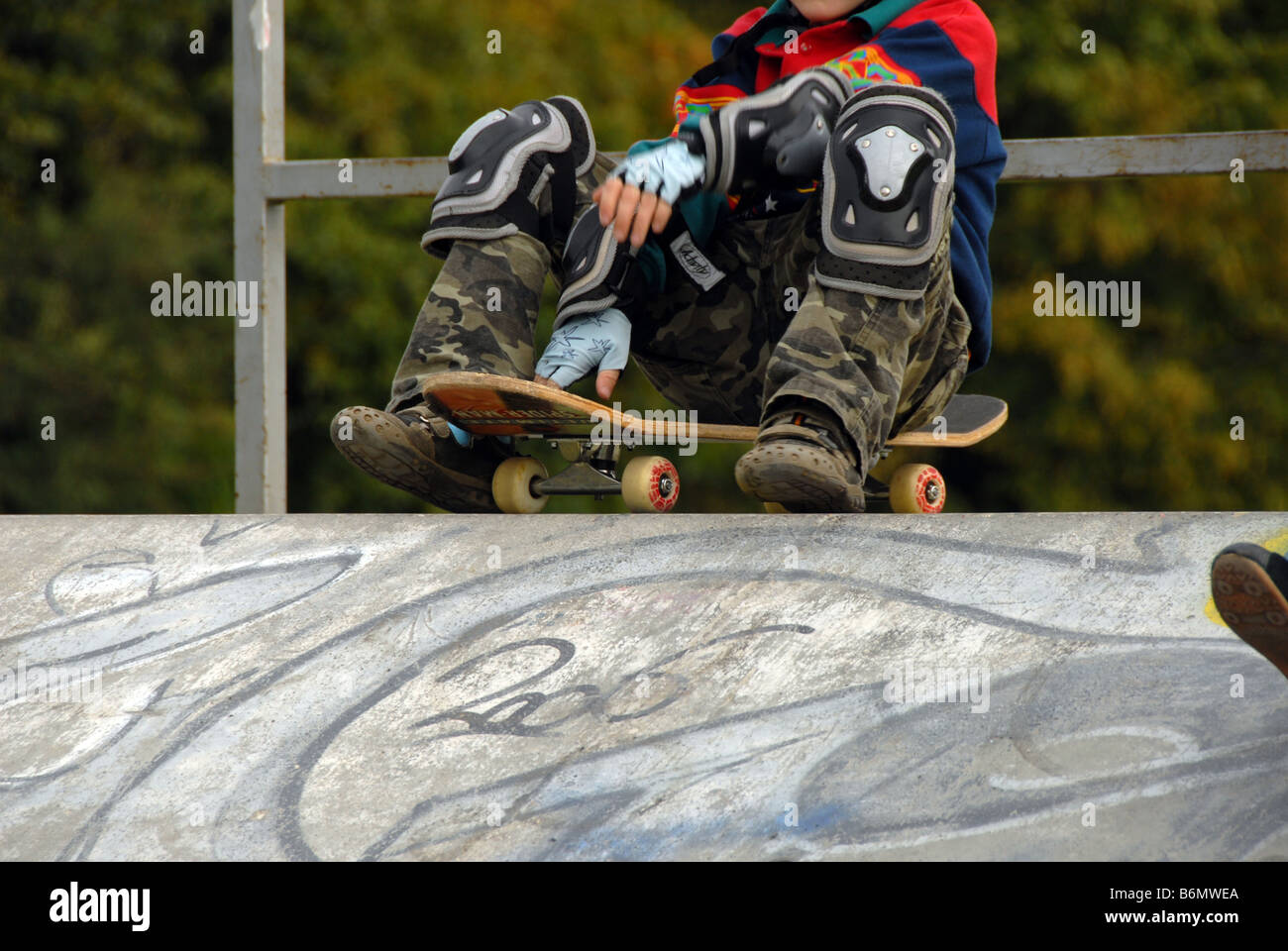 Young teen uses skateboard ramp at park Stock Photo - Alamy