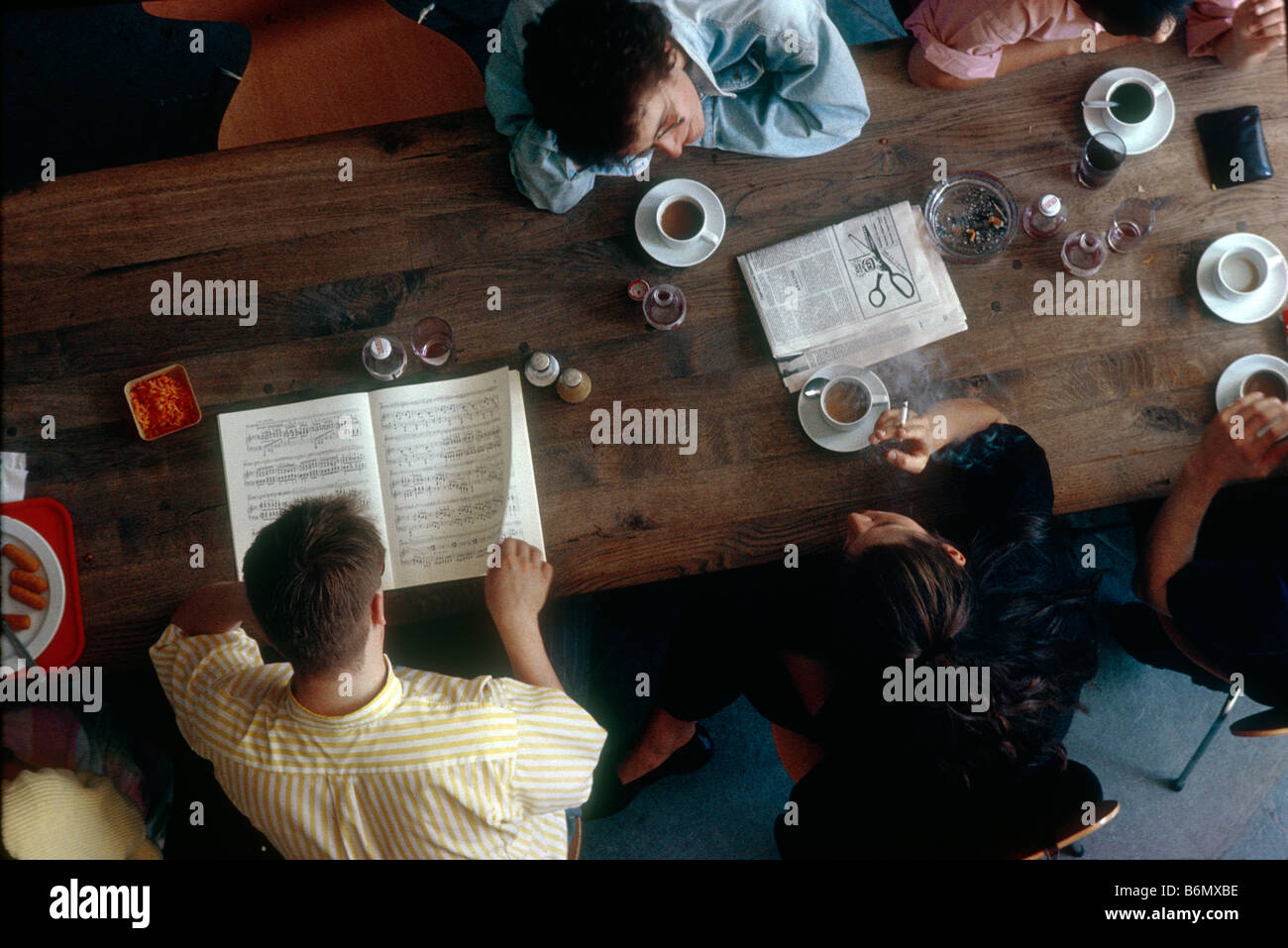 students at Music Highschool in Luebeck sitting on table in the canteen drinking coffee, smoking