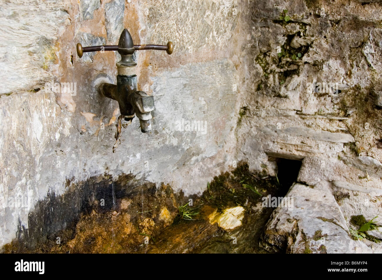 Old faucet on the wall Village of the Pyrenees Spain Stock Photo