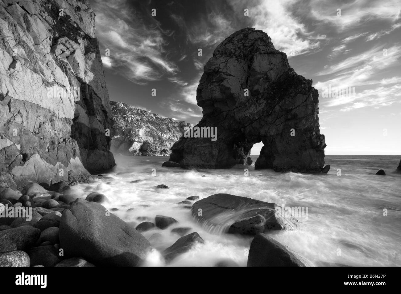 Wild coastline at sunset with big rock as subject Stock Photo Alamy