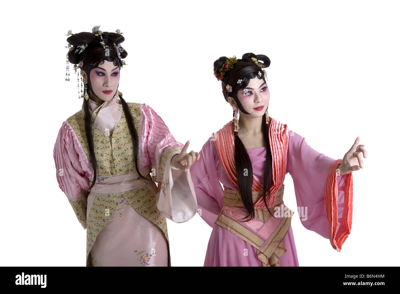 Two women wearing traditional clothing pointing up Stock Photo