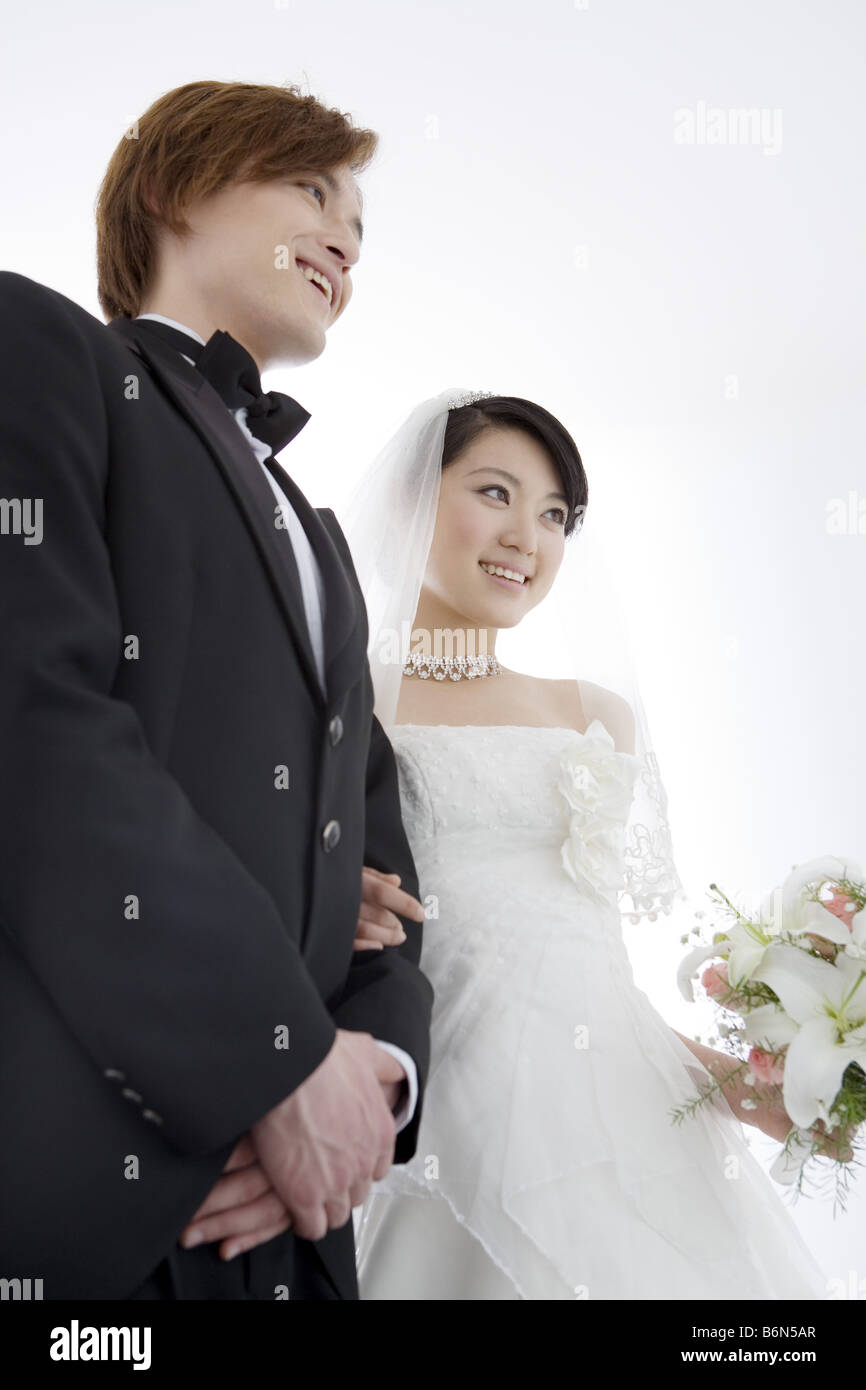 Bride and groom standing arm in arm Stock Photo