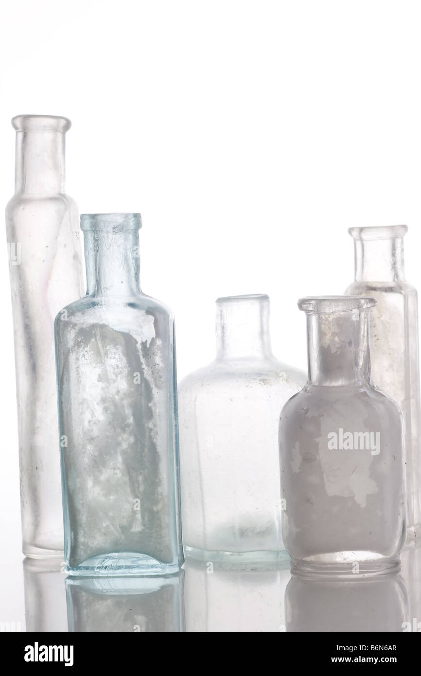 Antique bottles on white table with reflections Stock Photo
