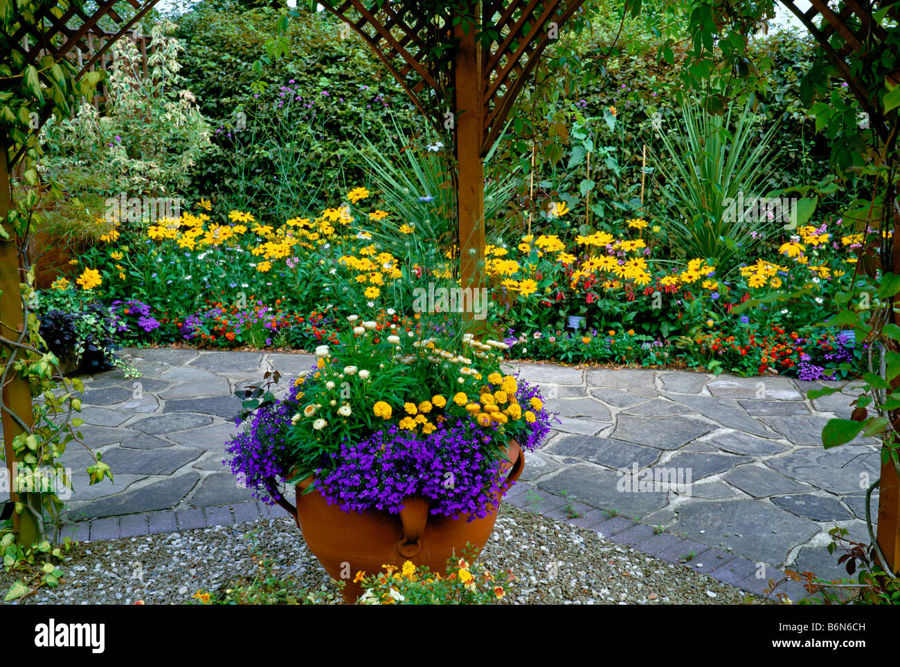 Bright Flower Border through Pergola Stock Photo