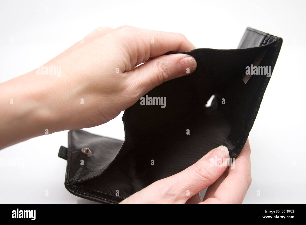 Concept of hand holding an empty wallet with a hole in the bottom
