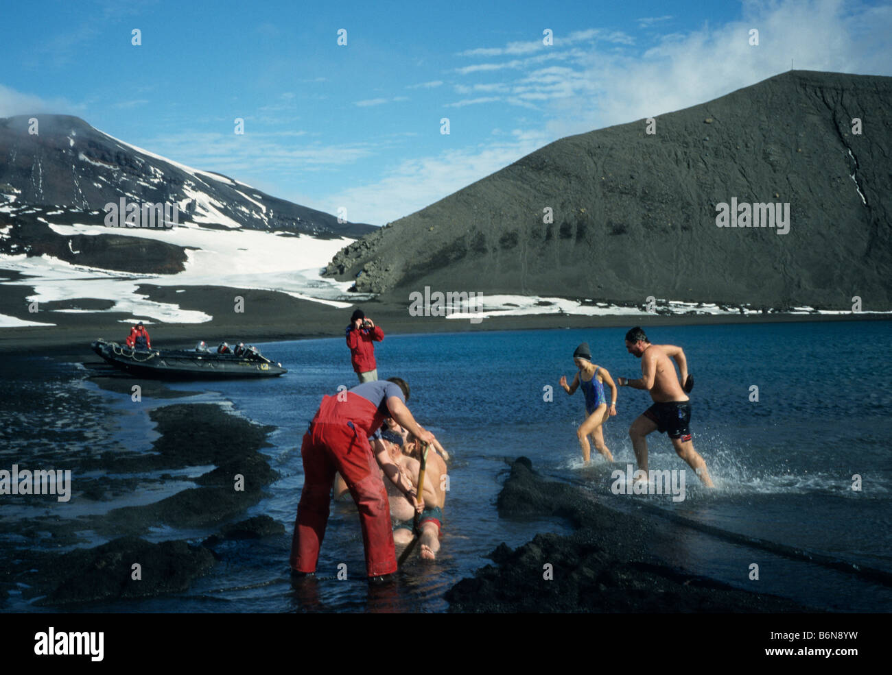 Tourists having a bath at the hot springs at Pendulum Cove, Deception Island, Antarctica. Stock Photo
