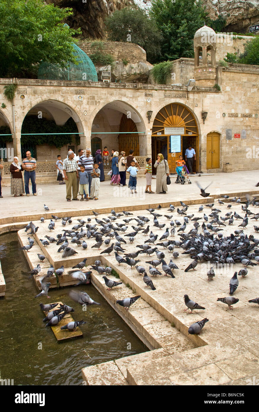 Sanliurfa (Urfa) Cave of Prophet Abraham, birthplace entrance with pigeons and pilgrims filling courtyard Stock Photo