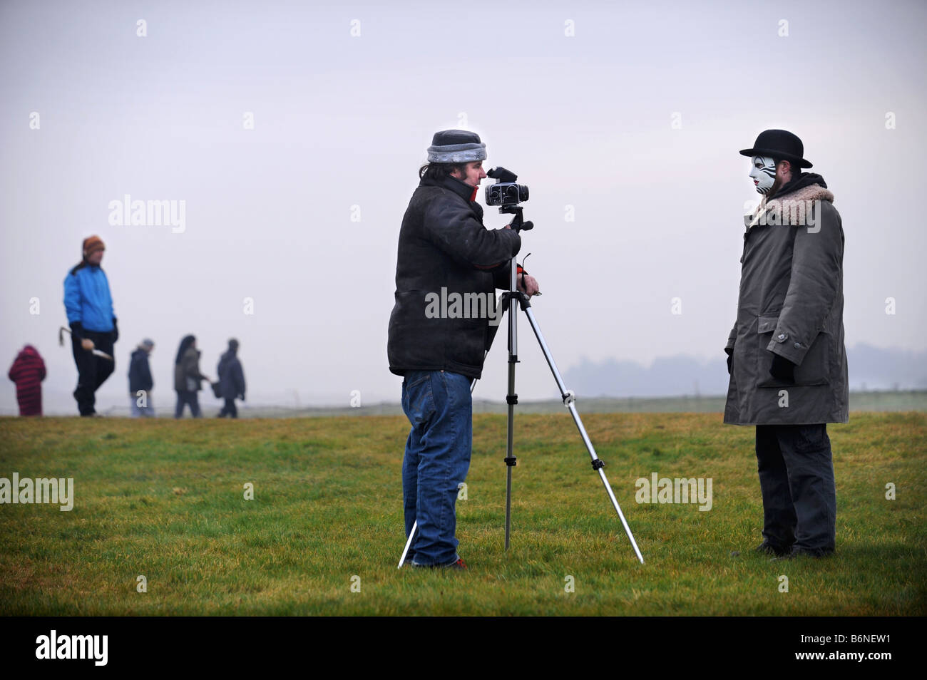 A VISITOR TO STONEHENGE WEARING A WHITEFACE CLOWN MASK IS PHOTOGRAPHED DURING THE CELEBRATIONS OF THE WINTER SOLSTICE WILTSHIRE Stock Photo