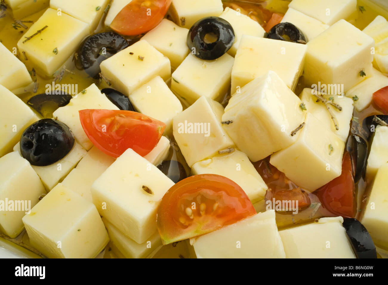 queso tomillo tomate y aceitunas en aceite de oliva virgen extra thyme cheese with tomato and olives in extra virgin olive oil Stock Photo