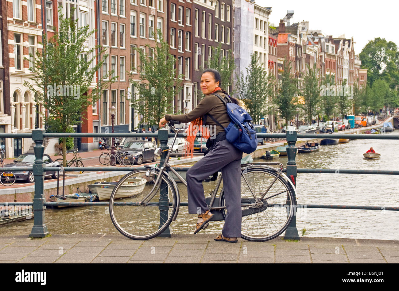 Amsterdam tourist with bike on bridge over canal Stock Photo
