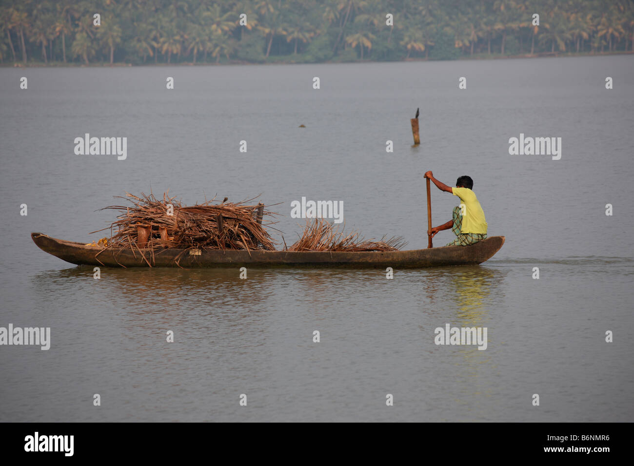 A boatman carrying goods on a boat Stock Photo
