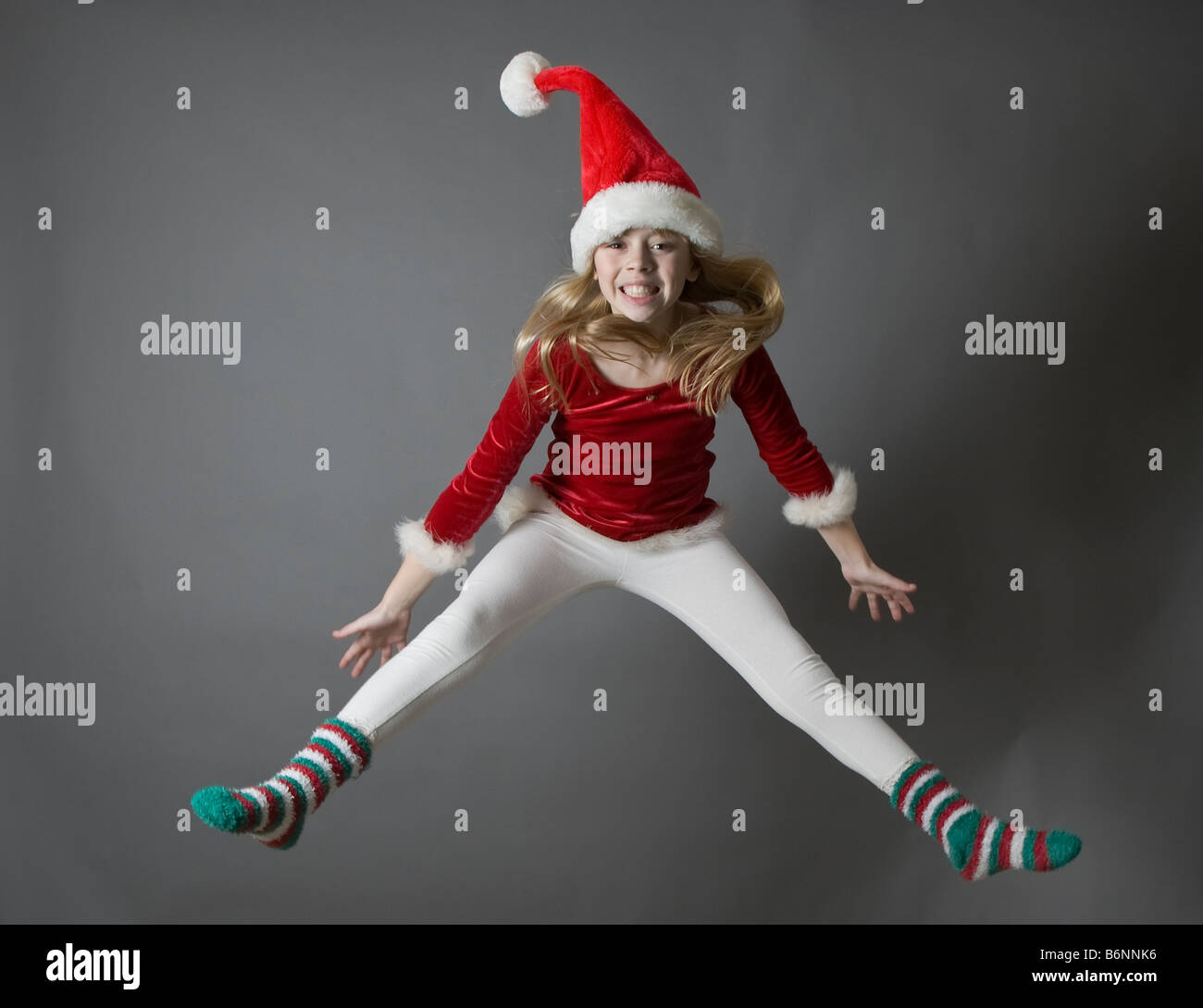 Child jumping wearing a Santa hat Stock Photo