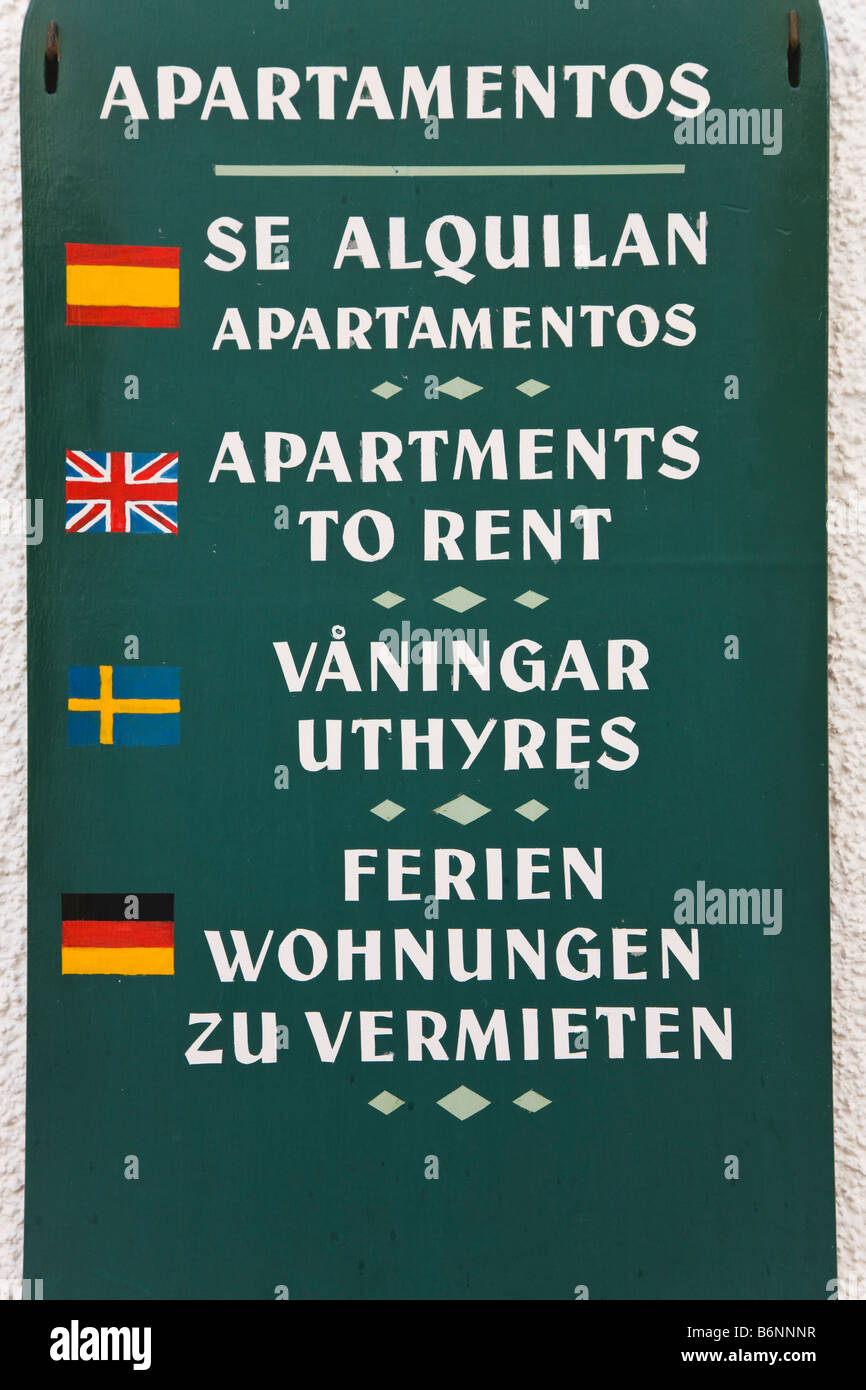 Sign in four languages in Torremolinos Spain offering apartments for rent Spanish English Swedish and German Stock Photo