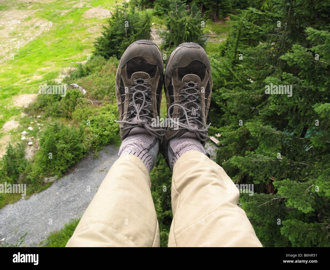 Feet hanging in midair from chairlift Stock Photo
