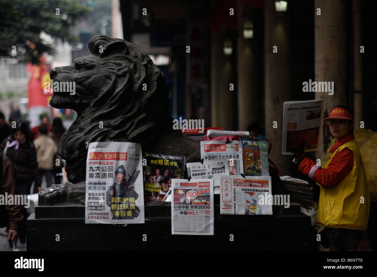CHineseCHinese girl sales newspapers in front of the Bus Terminal with the latest headlines in Guangzhou Guangding China People Stock Photo
