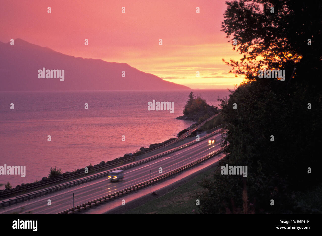 Sunset and clearing storm Turnagain Arm of Cook Inlet with Seward Highway near Bird Creek Alaska Stock Photo