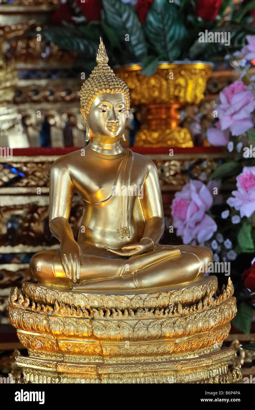 Buddha statue with pink roses in buddhist temple in Bangkok's chinatown
