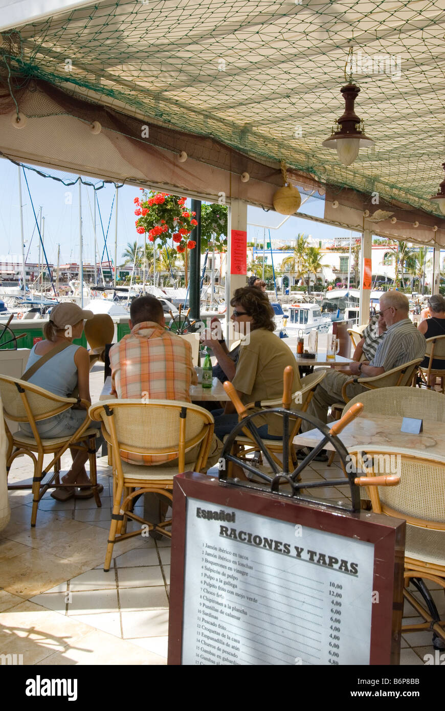 Tourists in seafront tapas bar marina restaurant in Puerto de Mogan Gran Canaria Canary Islands Spain Stock Photo
