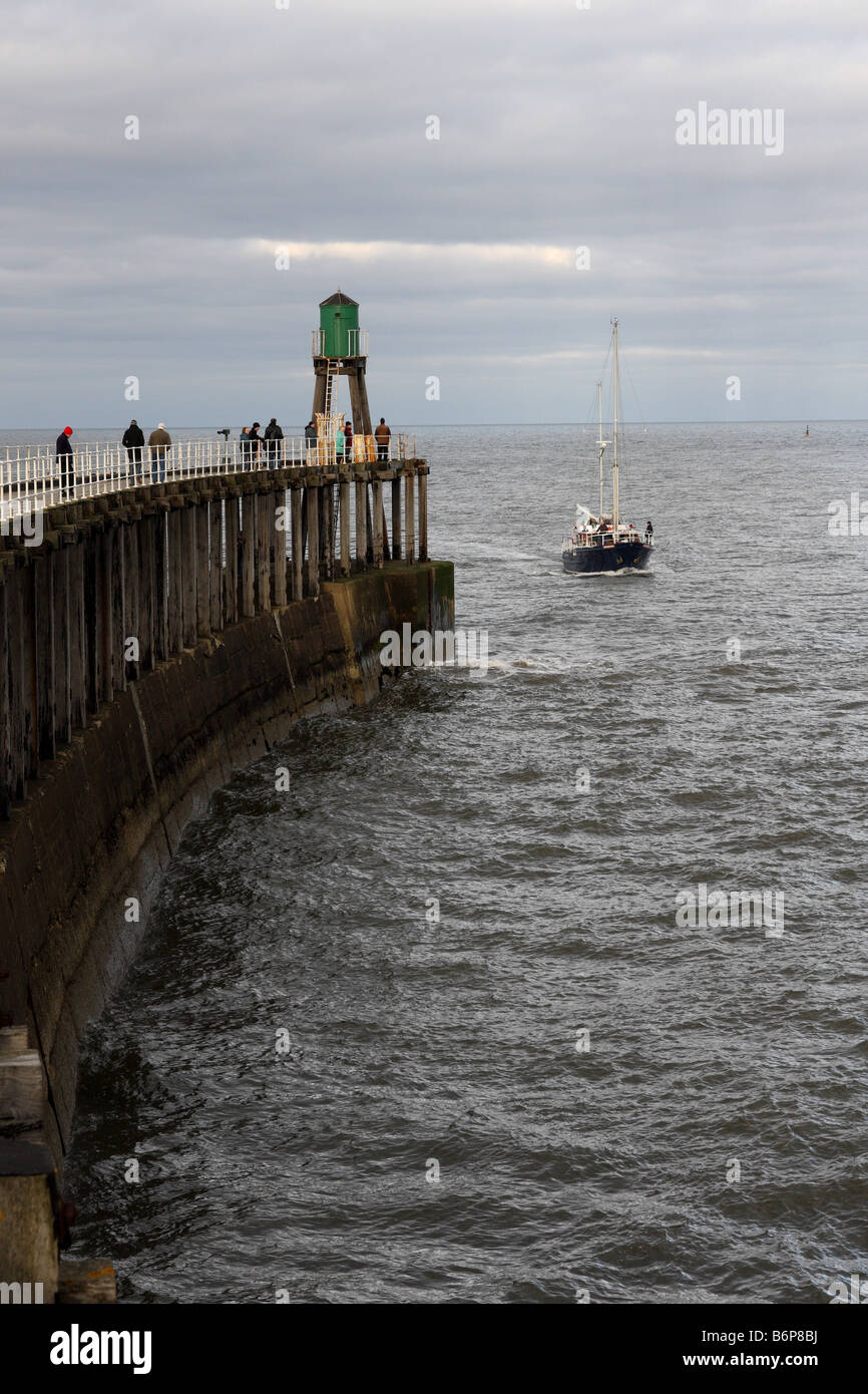 A yacht entering the Whitby harbour in north Yorkshire in England Stock ...