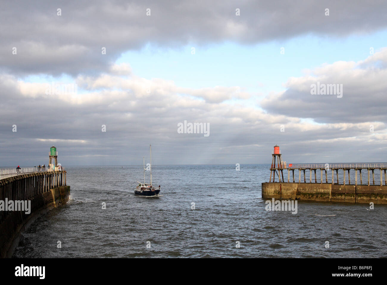 A yacht entering the Whitby harbour in north Yorkshire in England Stock ...