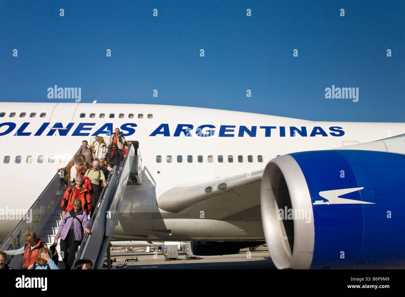 Passengers disembark an Aerolineas Argentinas Boeing 747 jumbo jet airplane aircraft in summer sunshine Buenos Aires Stock Photo