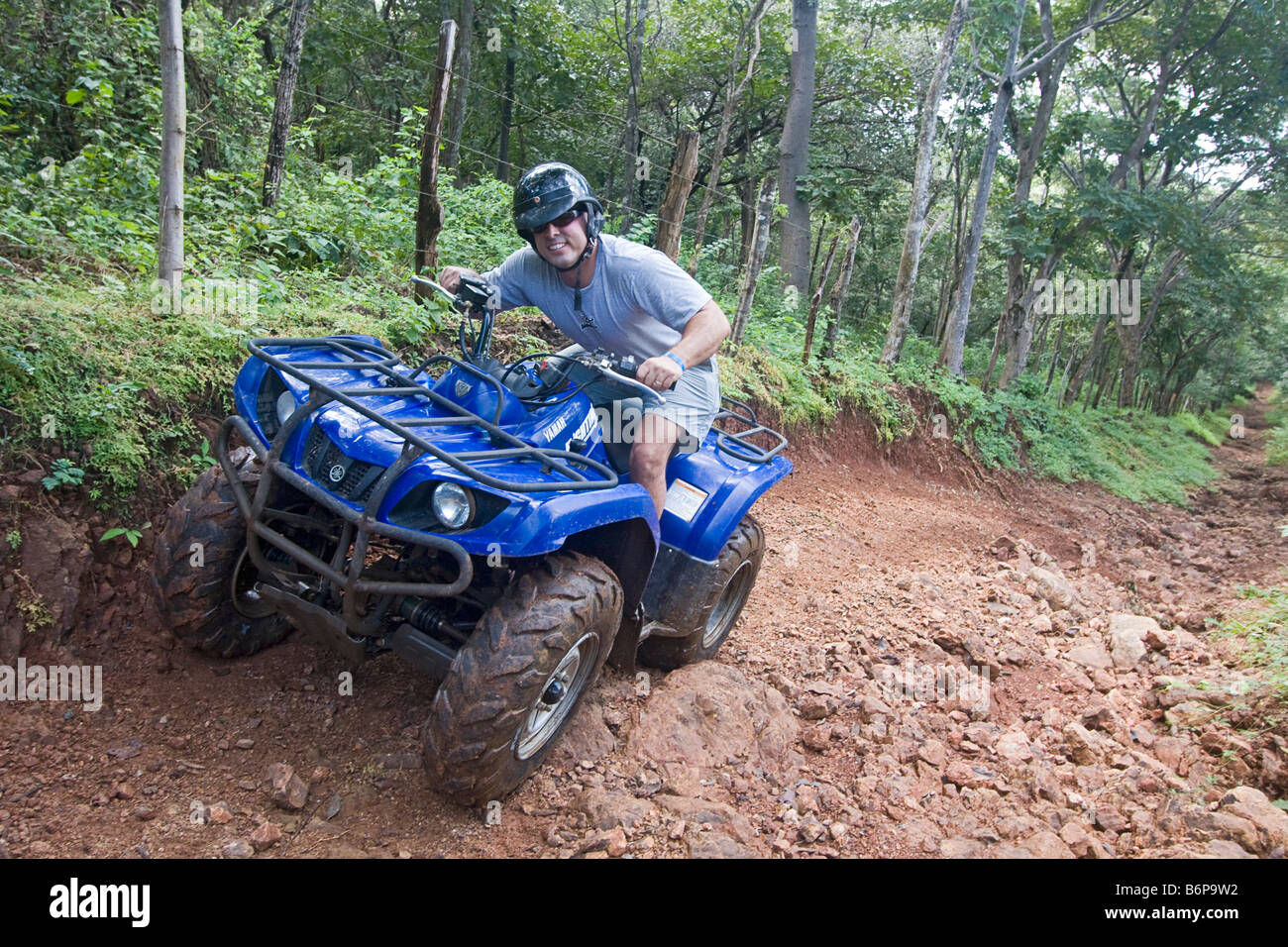 Visiting man rides ATV on tour of forest outside Tamarindo, Costa Rica Stock Photo