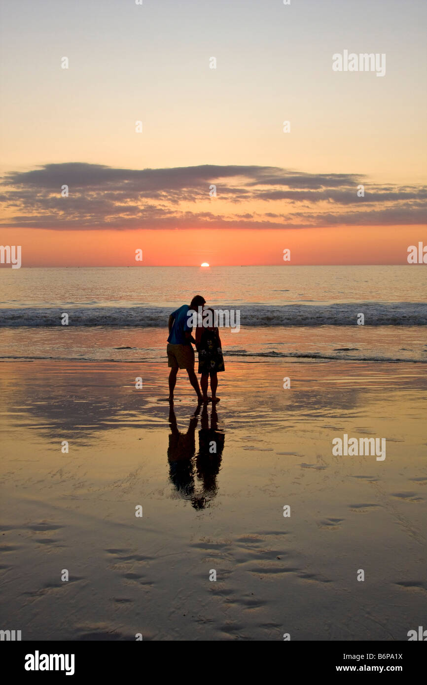 Loving couple kisses while enjoying the beach at sunset on Flamingo ...