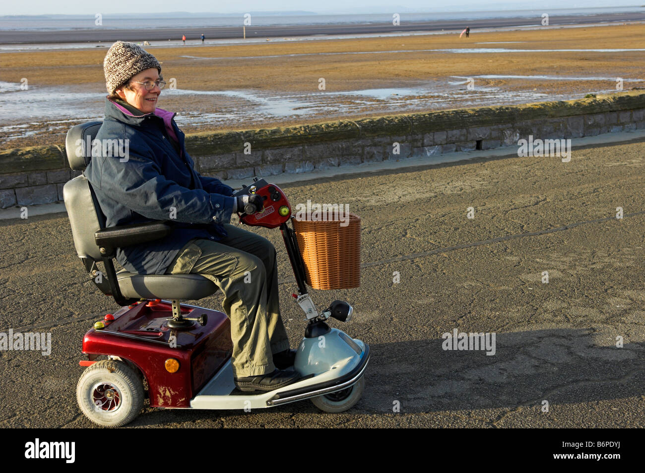 Late afternoon winter middle aged woman on excursion with electric wheelchair Stock Photo