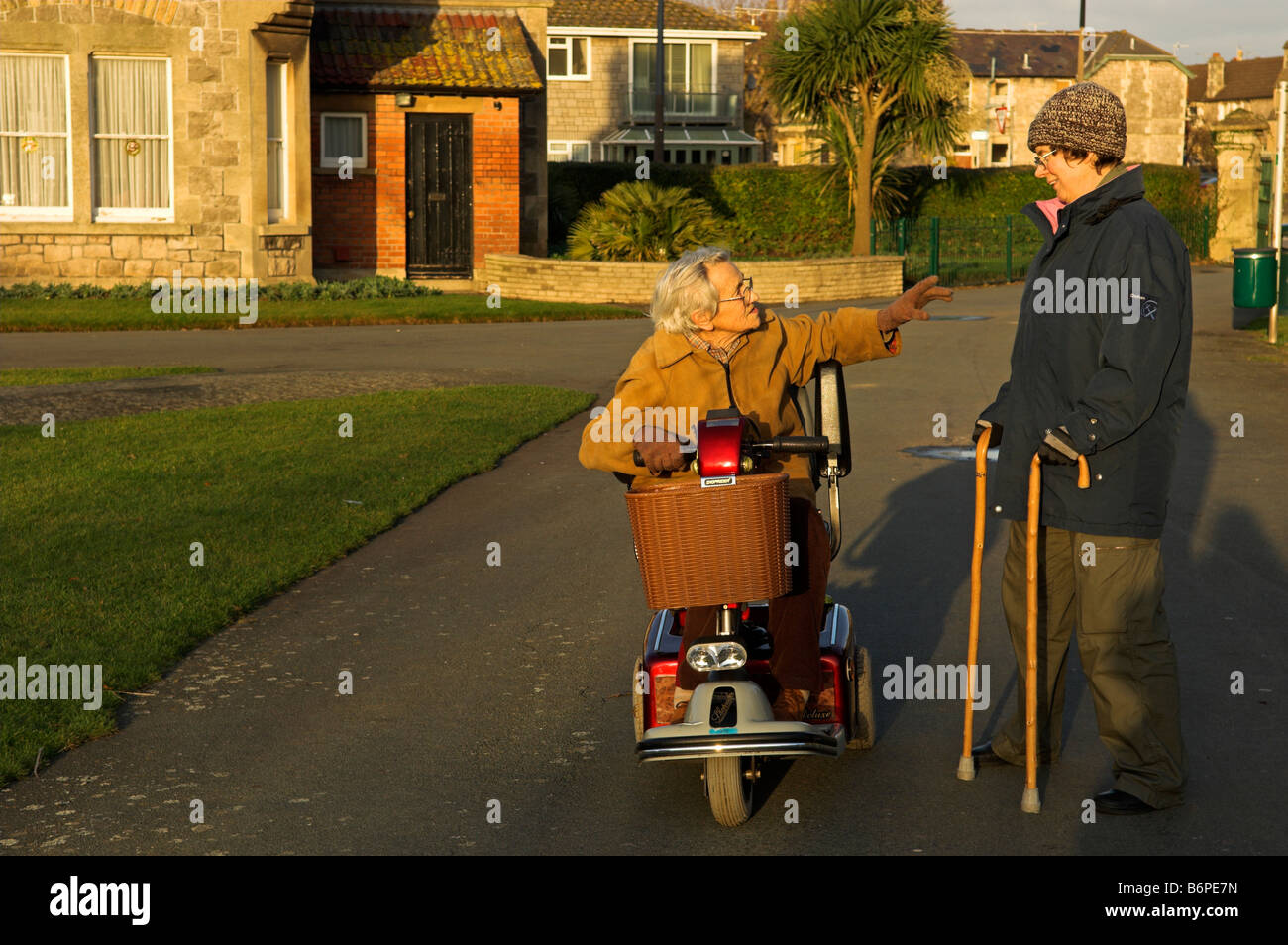 Elderly and middle aged disabled women talking while on a winter afternoon outing Weston Super Mare North Somerset England Stock Photo