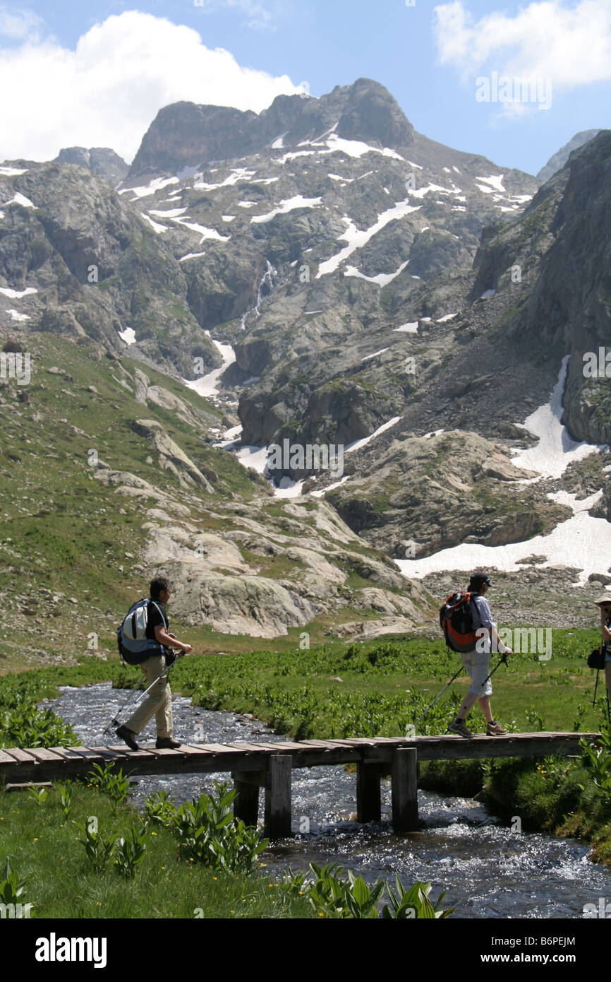 walkers crossing a bridge in upper Val Gordolosaque, Mercantour National Park, Alpes Maritimes France Stock Photo