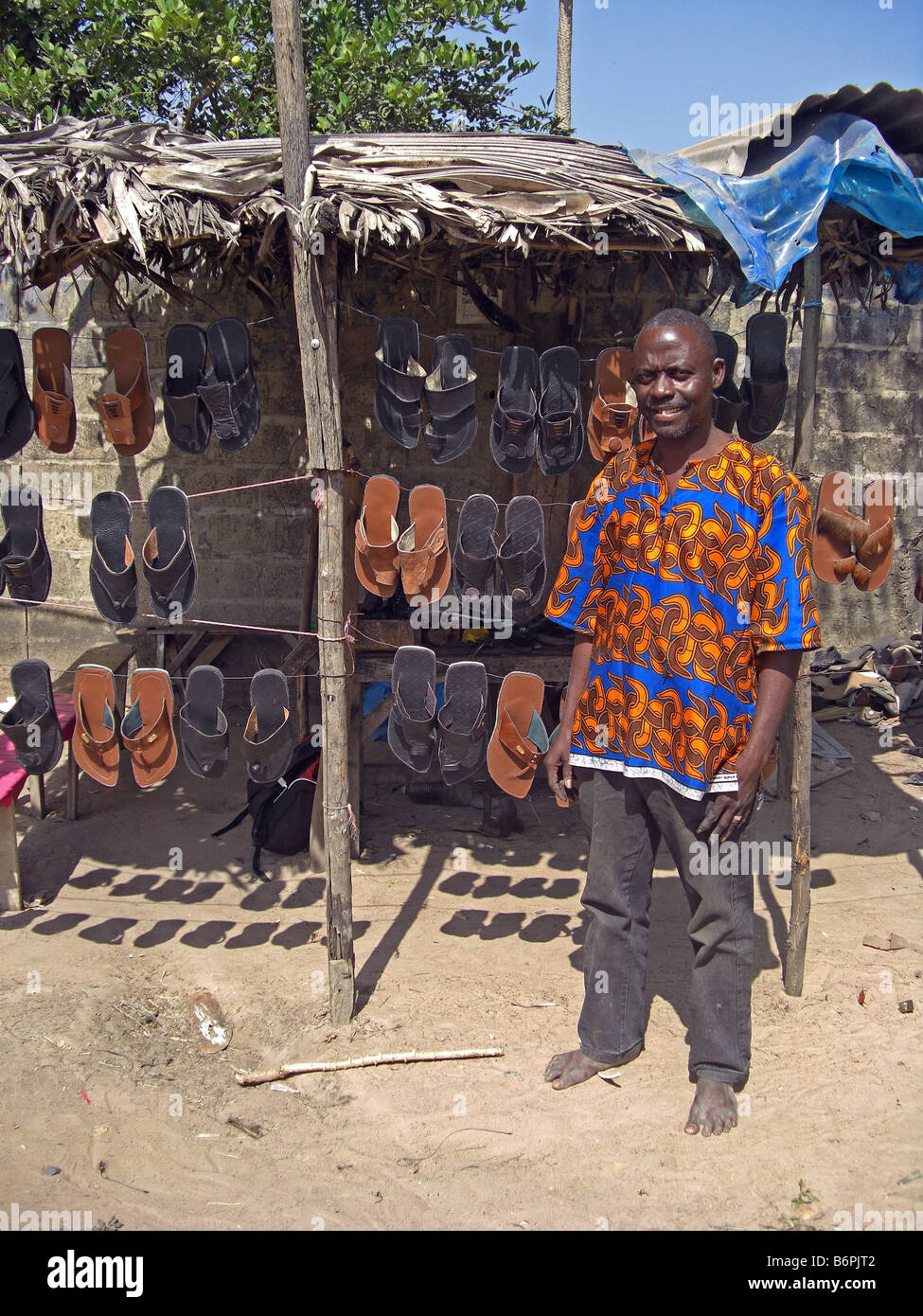 A shoe maker out side his work place and shop in The Gambia West Africa ...