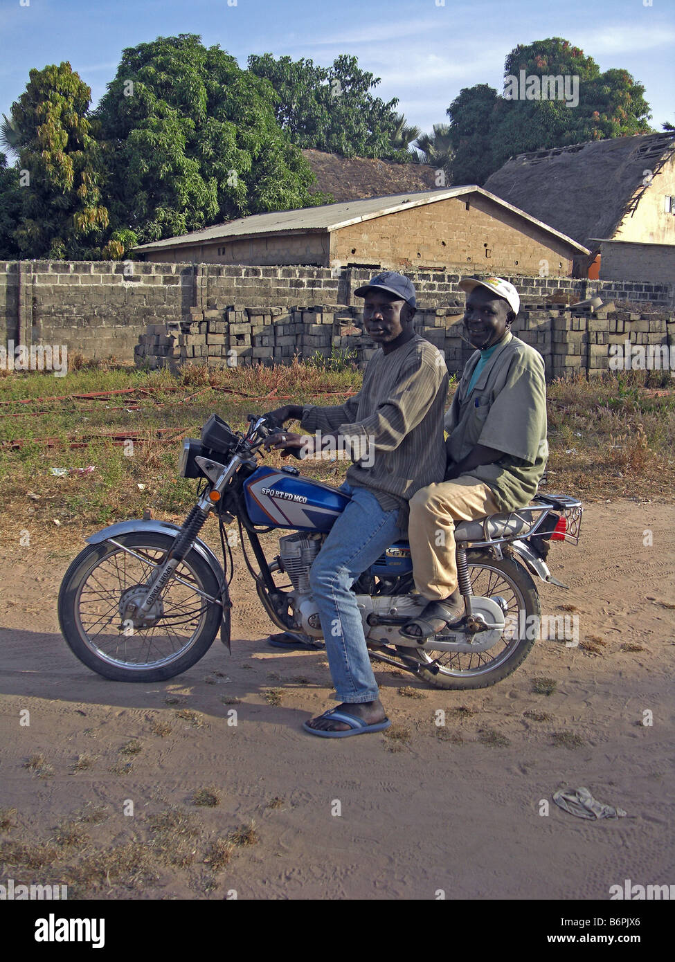 Two men on a motobike with no helmets in The Gambia, West africa. Stock Photo