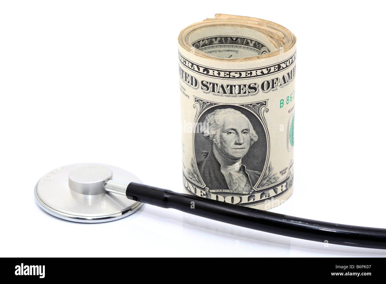 expensive health treatment stethoscope and dollars rolled Stock Photo