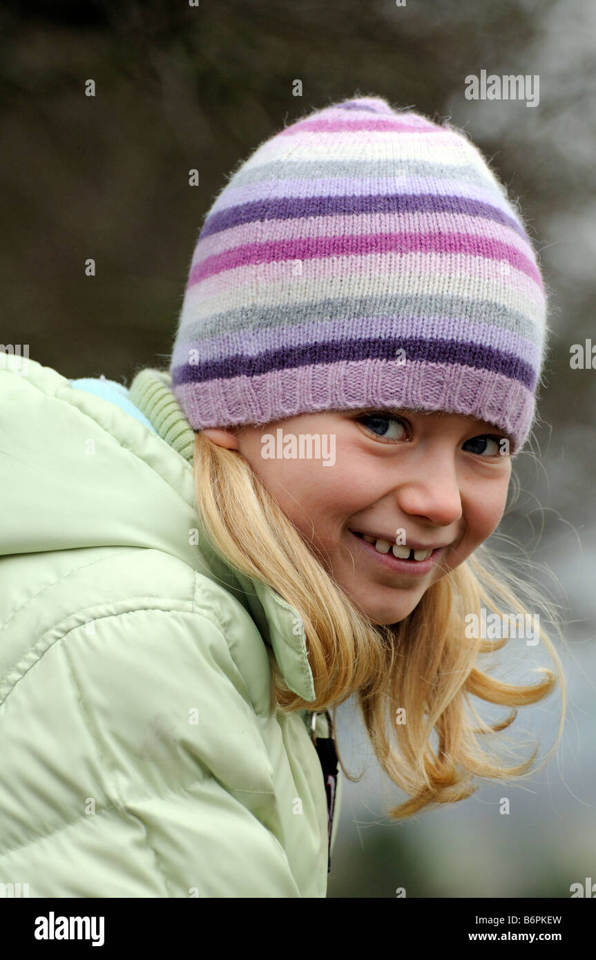 Portrait of a little girl smiling and wearing warm clothes with a ...