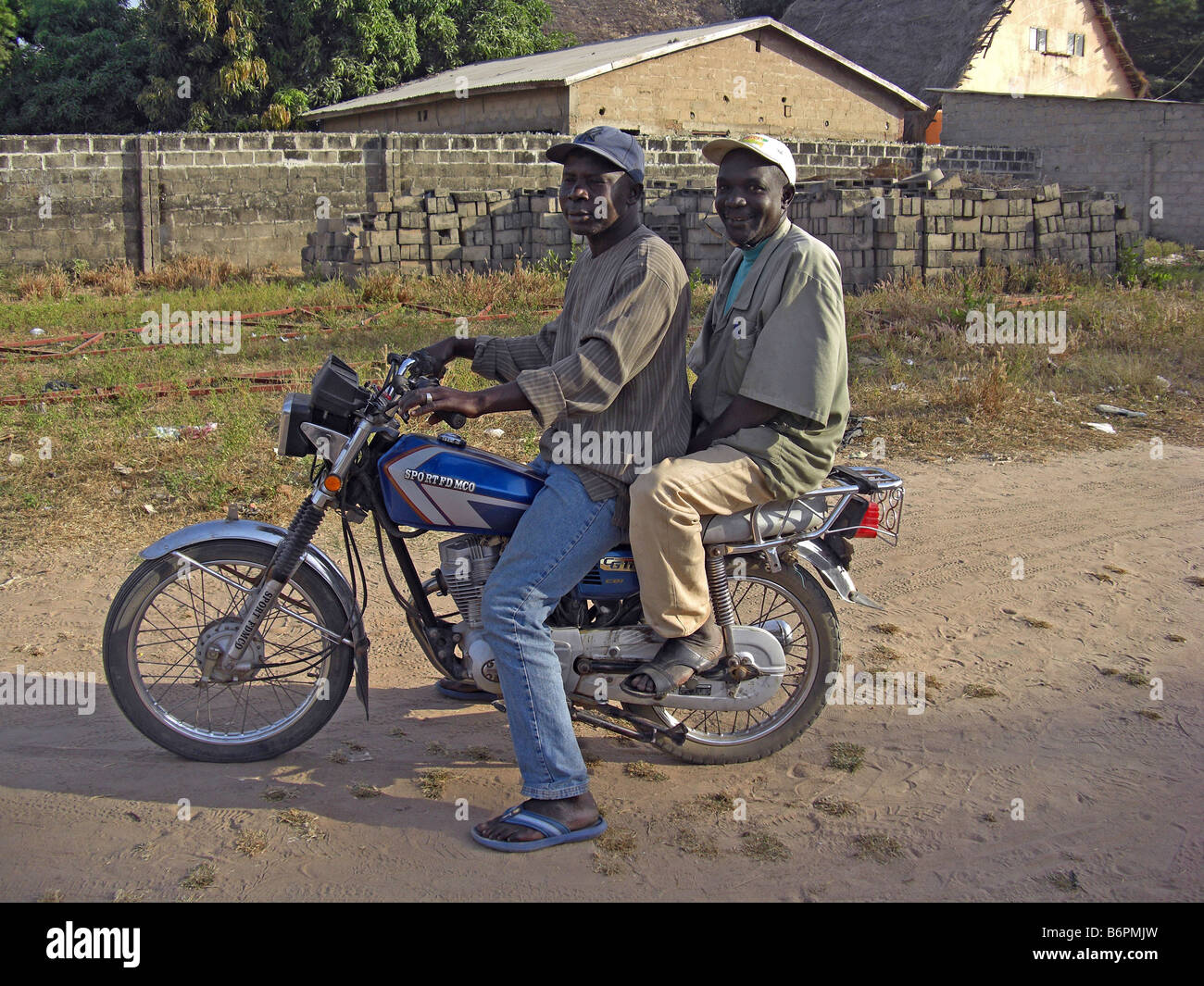 Two men on a motobike with no helmets in The Gambia, West africa Stock Photo