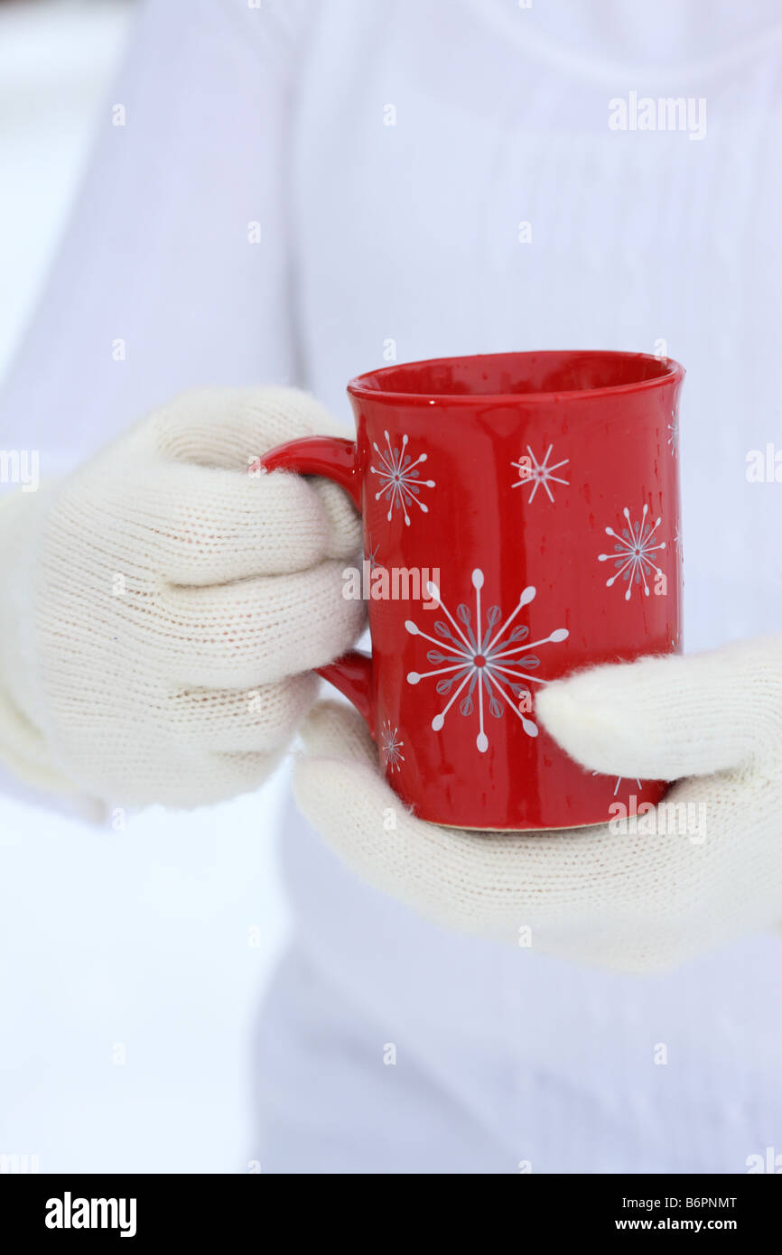 Hands with winter gloves holding Christmas Coffee Mug Stock Photo - Alamy
