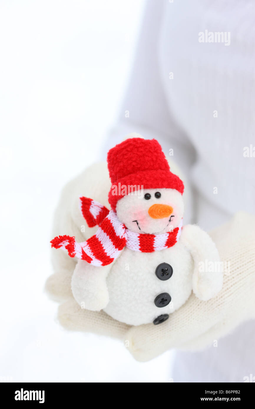 Hands with winter gloves holding Christmas Snowman Stock Photo
