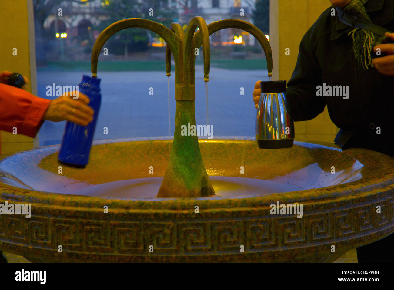 Filling thermos bottles with hot water from the public mineral spring Kochbrunnen ('boiling fountain') in Wiesbaden, Germany Stock Photo