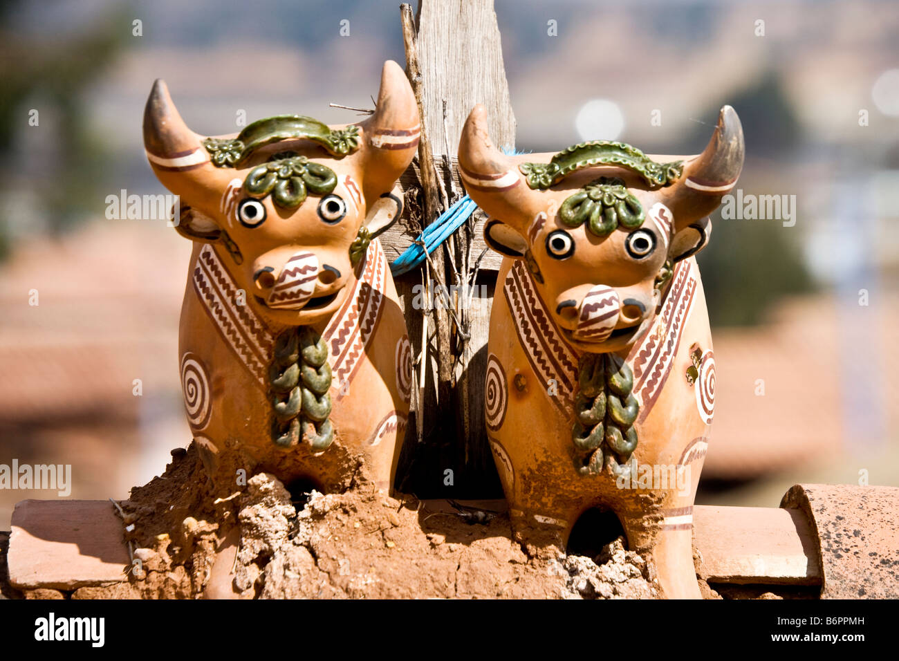 A pair of Toritos de Pucara or Little Bulls of Pucara atop a roof in Chinchero Peru South America Stock Photo