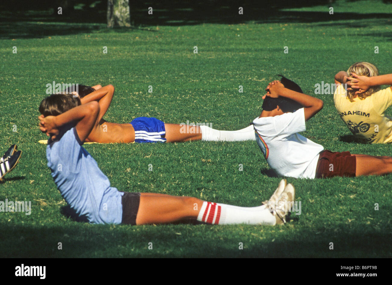 Teen boys do situps before soccer practice in California Stock Photo