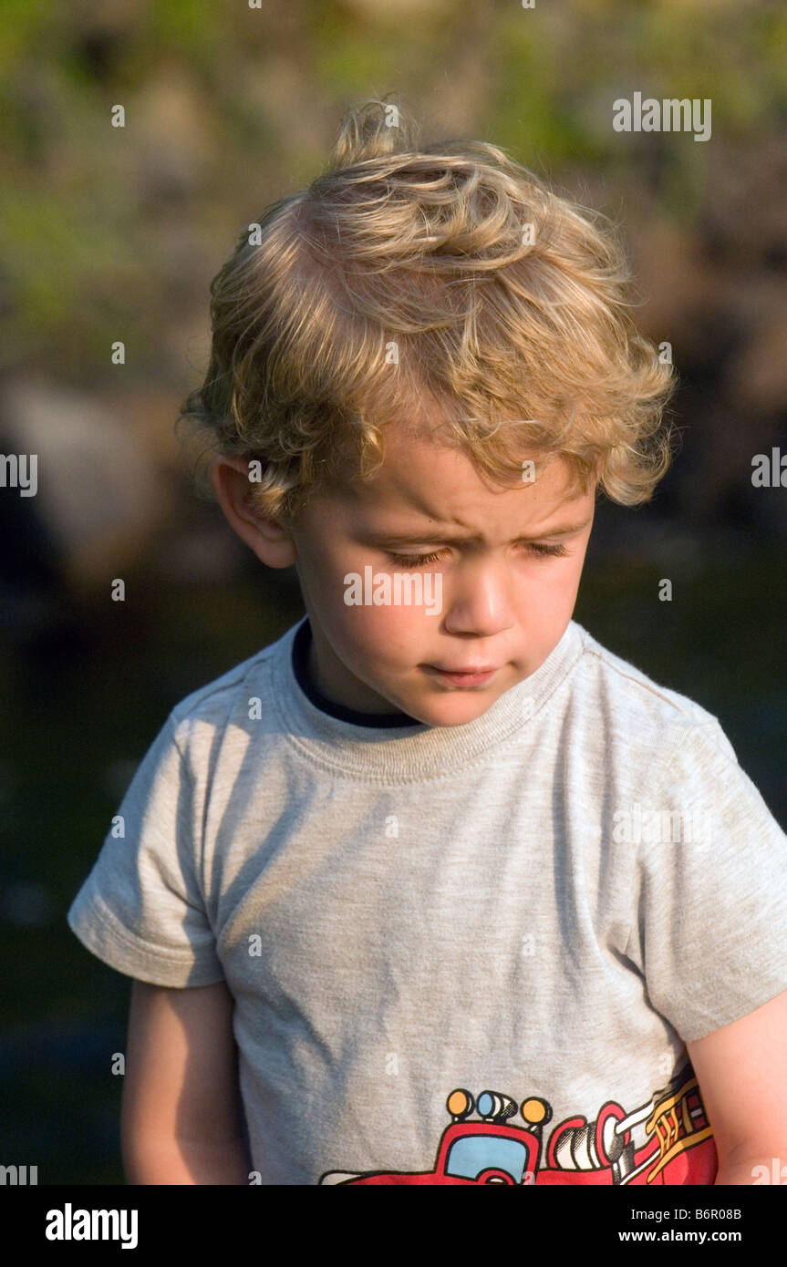 Young blond boy looking sad Stock Photo