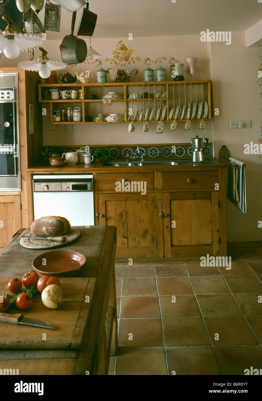 Large old butchers block in country kitchen with terracotta tiled floor
