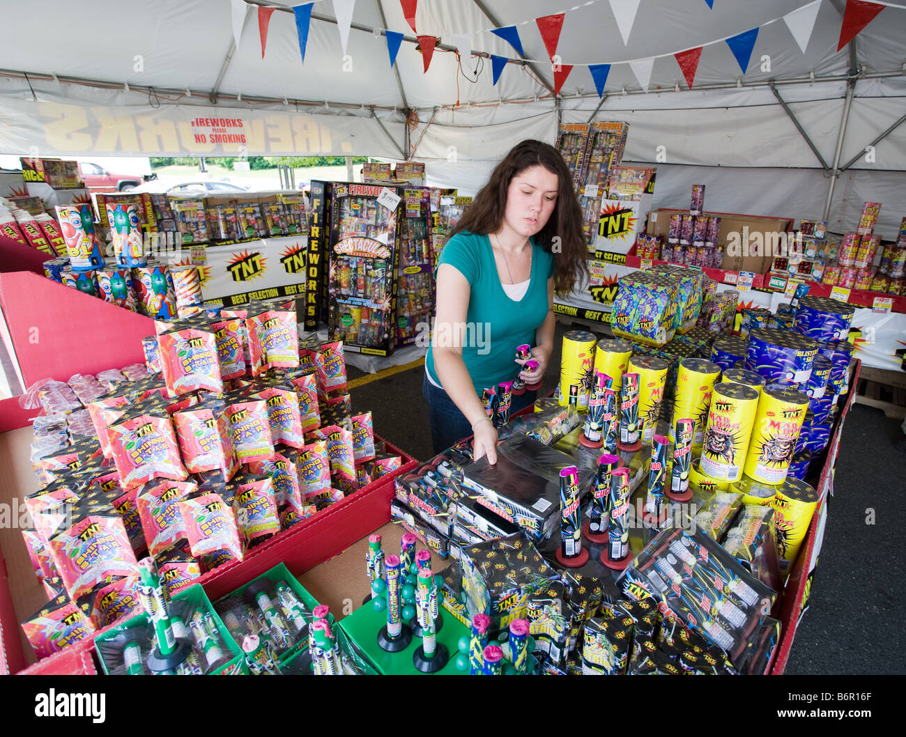 A young woman sells legal fireworks in a roadside stand tent in Milford Connecticut USA Stock Photo